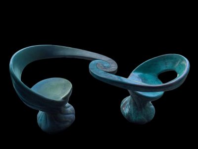 The Unity Chairs. Cast bronze, 36 inches high x 5.5 ft long x 24 inches wide. Page In the Sun Café, Puerto Vallarta, Mexico. With two different colors or the same colors, the two interlocking bronze chairs compel people to sit facing each other, encouraging companionship.